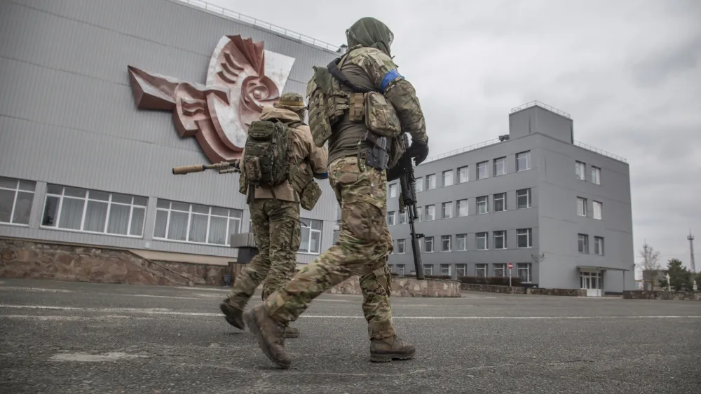 Ukrainian servicemen walk at the Chernobyl nuclear plant, in Chernobyl, Ukraine, Tuesday, April 5, 2022. (AP Photo/Oleksandr Ratushniak)