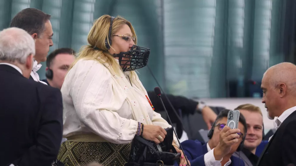 Diana Iovanovici-Sosoaca, European Parliament member and a far-right Romanian politician, wears a muzzle on her face as she is escorted out, before a vote to choose the next President of the European Commission, at the European Parliament in Strasbourg, France, July 18, 2024. REUTERS/Johanna Geron