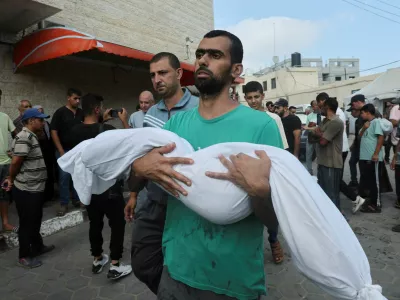 A Palestinian man carries the body of a loved one killed in Israeli strikes, amid the Israel-Hamas conflict, outside Al-Aqsa Martyrs Hospital in Deir Al-Balah in the central Gaza Strip, July 16, 2024. REUTERS/Ramadan Abed