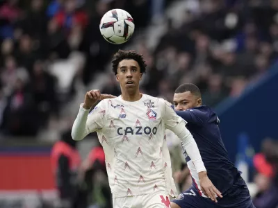 FILE - Lille's Leny Yoro controls the ball next to PSG's Kylian Mbappe, right, during the French League One soccer match between Paris Saint-Germain and Lille at the Parc des Princes stadium, in Paris, France, Sunday, Feb. 19, 2023. Manchester United completed the signing of 18-year-old defender Leny Yoro from Lille on Thursday, July 18, 2024. (AP Photo/Christophe Ena, File)