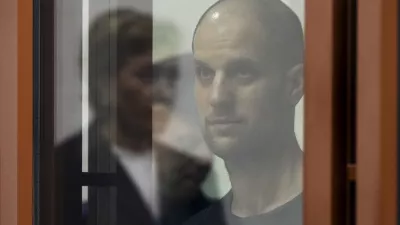 Wall Street Journal reporter Evan Gershkovich stands listening to the verdict in a glass cage of a courtroom inside the building of "Palace of justice," in Yekaterinburg, Russia, on Friday, July 19, 2024. A Russian court convicted Gershkovich on espionage charges that his employer and the U.S. have rejected as fabricated. He was sentenced to 16 years in prison after a secretive and rapid trial in the country's highly politicized legal system. (AP Photo/Dmitri Lovetsky)