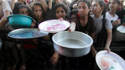 Palestinian children gather to receive food cooked by a charity kitchen, amid food scarcity, as Israel-Hamas conflict continues, in the northern Gaza Strip, July 18, 2024. REUTERS/Mahmoud Issa