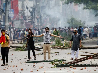 A demonstrator gestures as protesters clash with Border Guard Bangladesh (BGB) and the police outside the state-owned Bangladesh Television as violence erupts across the country after anti-quota protests by students, in Dhaka, Bangladesh, July 19, 2024. REUTERS/Mohammad Ponir Hossain   TPX IMAGES OF THE DAY