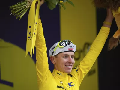 Slovenia's Tadej Pogacar, wearing the overall leader's yellow jersey, celebrates on the podium after during the nineteenth stage of the Tour de France cycling race over 144.6 kilometers (89.9 miles) with start in Embrun and finish in Isola 2000, France, Friday, July 19, 2024. (AP Photo/Daniel Cole)