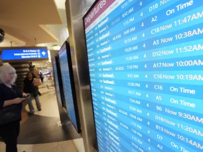 Passengers check a departures board at Phoenix Sky Harbor International Airport Friday, July 19, 2024, in Phoenix. An overnight outage was blamed on a software update that cybersecurity firm CrowdStrike sent to Microsoft computers of its corporate customers including many airlines. (AP Photo/Ross D. Franklin)