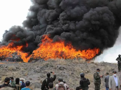 Members of Houthi security forces stand near a fire as Houthi de facto authorities burn seized narcotics, in Sanaa, Yemen July 20, 2024. REUTERS/Khaled Abdullah