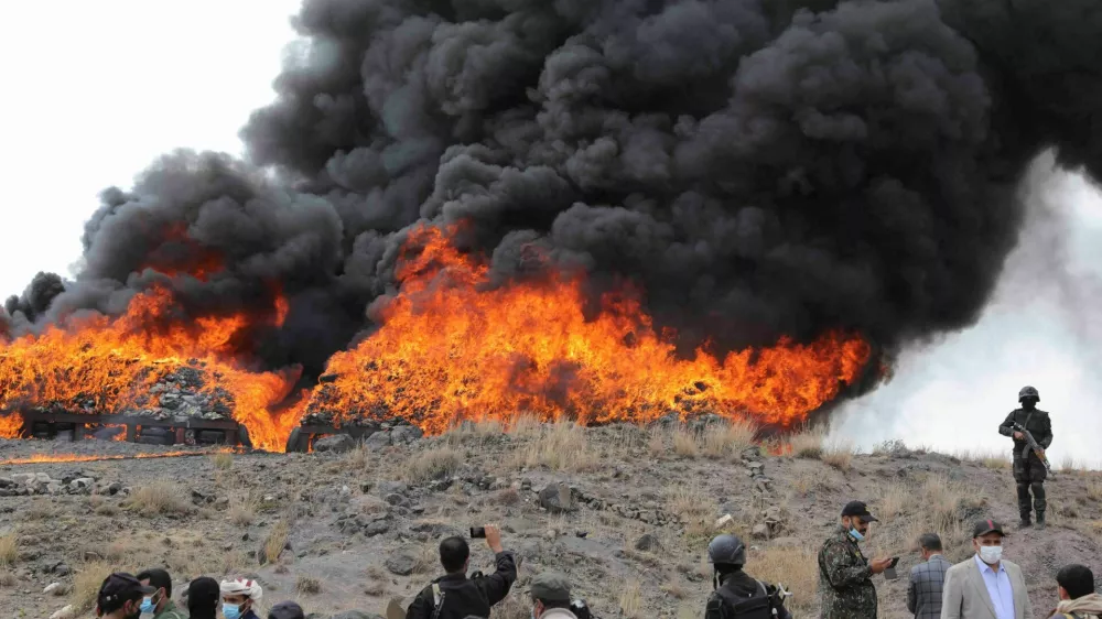 Members of Houthi security forces stand near a fire as Houthi de facto authorities burn seized narcotics, in Sanaa, Yemen July 20, 2024. REUTERS/Khaled Abdullah