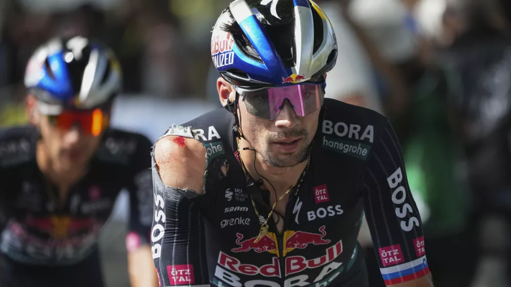 Slovenia's Primoz Roglic crosses the finish line with a shoulder injury after crashing in the last kilometers of the twelfth stage of the Tour de France cycling race over 203.6 kilometers (126.5 miles) with start in Aurillac and finish in Villeneuve-sur-Lot, France, Thursday, July 11, 2024. (AP Photo/Daniel Cole)