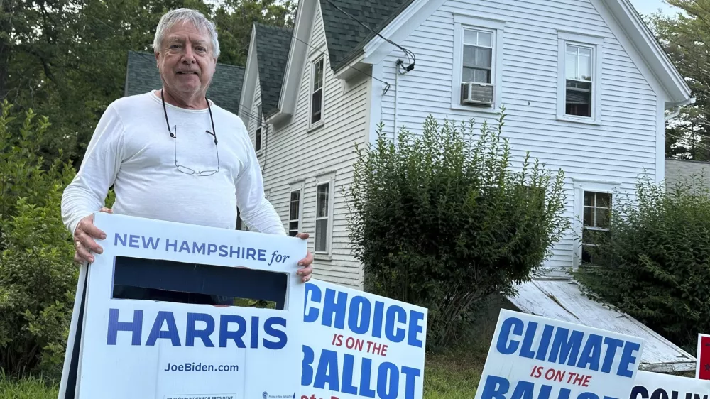 Voter Tom Chase displays a campaign sign with President Joe Biden's name cut out in Northwood, N.H., Sunday, July 21, 2024. Chase, 79, said he removed Biden's name last week and was relieved and delighted that the president withdrew from his 2024 campaign and endorsed Vice President Kamala Harris. (AP Photo/Holly Ramer)