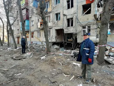 A man looks on as he stands next to a residential building hit in a military strike, amid Russia's invasion, in Kharkiv, Ukraine, April 10, 2022. REUTERS/Oleksandr Lapshyn