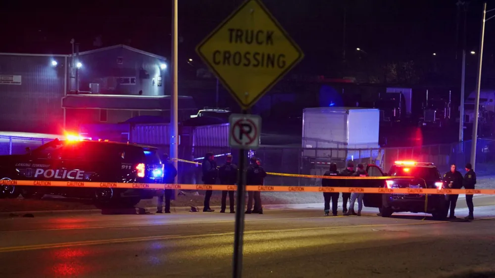 Police officers surround a scene where the suspect was located as they respond to a shooting at Michigan State University in East Lansing, Michigan, U.S., February 14, 2023.  REUTERS/Dieu-Nalio Chery 