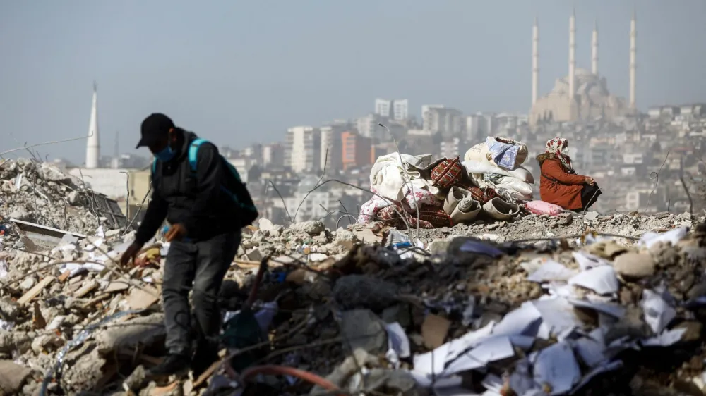 A woman sits on the rubble of her house in the aftermath of a deadly earthquake in Kahramanmaras, Turkey February 14, 2023. REUTERS/Nir Elias