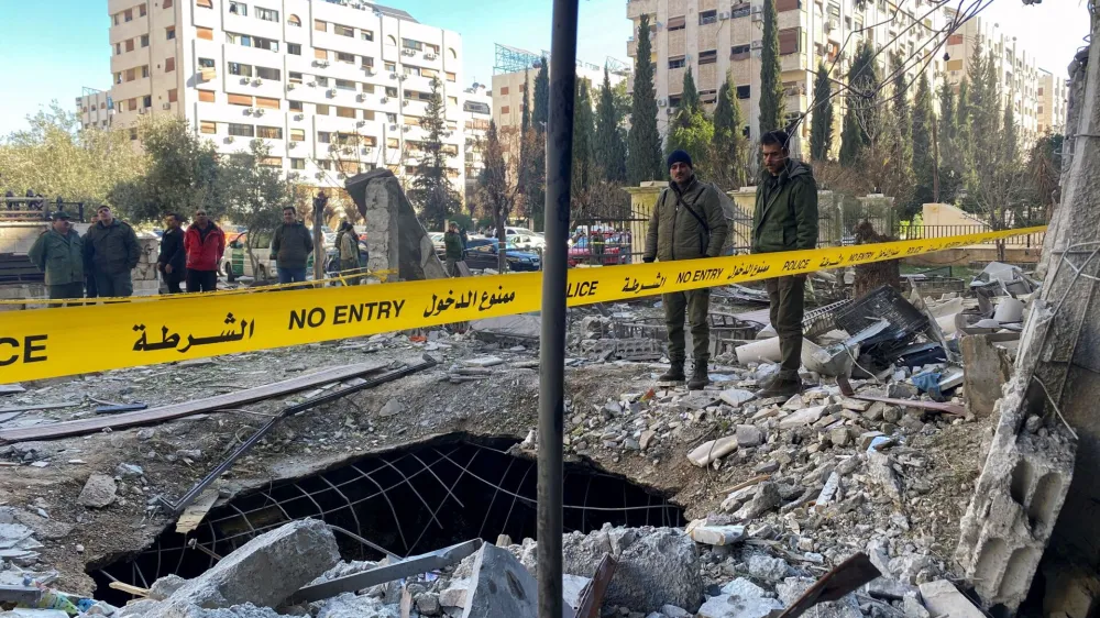 Police officers stand on the rubble of a damaged building at the site of a rocket attack, in central Damascus' Kafr Sousa neighborhood, Syria, February 19, 2023. REUTERS/Firas Makdessi