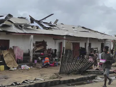 A man walks by damaged building, in Mananjary district, Madagascar, Wednesday Feb. 22, 2023 after cyclone Freddy reached Madagascar. A slightly weakened Cyclone Freddy has made landfall in Madagascar, where schools, businesses and public transportation were shut down ahead of its arrival. Freddy was packing winds gusting to 180 kilometers per hour, or about 111 miles per hour, as it came ashore in a nation already hit in January by a tropical storm that killed at least 30 people. (AP Photo/Solofo Rasolofomanana)