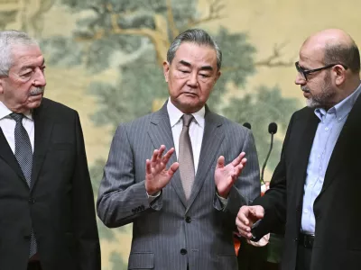 China's Foreign Minister Wang Yi, center, hosts an event for Mahmoud al-Aloul, left, vice chairman of Fatah, and Mussa Abu Marzuk, a senior member of Hamas, to meet at the Diaoyutai State Guesthouse in Beijing, Tuesday, July 23, 2024. (Pedro Pardo/Pool Photo via AP)