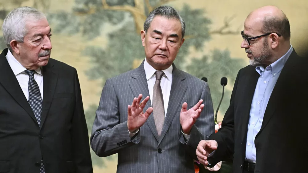 China's Foreign Minister Wang Yi, center, hosts an event for Mahmoud al-Aloul, left, vice chairman of Fatah, and Mussa Abu Marzuk, a senior member of Hamas, to meet at the Diaoyutai State Guesthouse in Beijing, Tuesday, July 23, 2024. (Pedro Pardo/Pool Photo via AP)