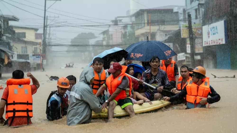 Rescuers assist residents on a boat as they wade through a flooded road following heavy rains brought by Typhoon Gaemi, in Marikina City, Metro Manila, Philippines, July 24, 2024. REUTERS/Lisa Marie David