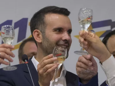 Milojko Spajic, president of the centrist Europe Now party raises a glass of champagne at his headquarters after parliamentary election in Montenegro's capital Podgorica, Sunday, June 11, 2023. A recently formed centrist group that advocates Montenegro joining the European Union was projected to win the small Balkan country's early parliamentary election Sunday, but without enough support to form a government on its own, according to independent vote monitors. (AP Photo/Risto Bozovic)