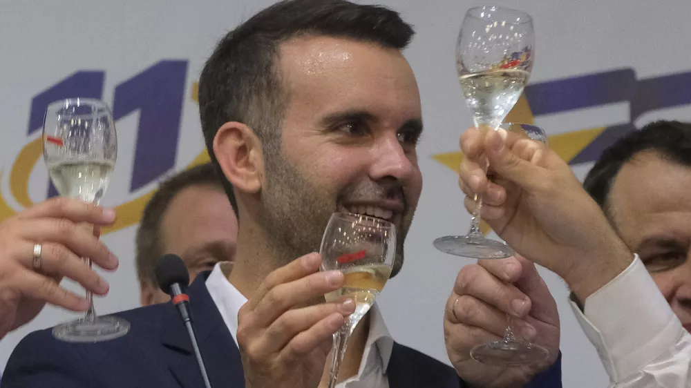 Milojko Spajic, president of the centrist Europe Now party raises a glass of champagne at his headquarters after parliamentary election in Montenegro's capital Podgorica, Sunday, June 11, 2023. A recently formed centrist group that advocates Montenegro joining the European Union was projected to win the small Balkan country's early parliamentary election Sunday, but without enough support to form a government on its own, according to independent vote monitors. (AP Photo/Risto Bozovic)