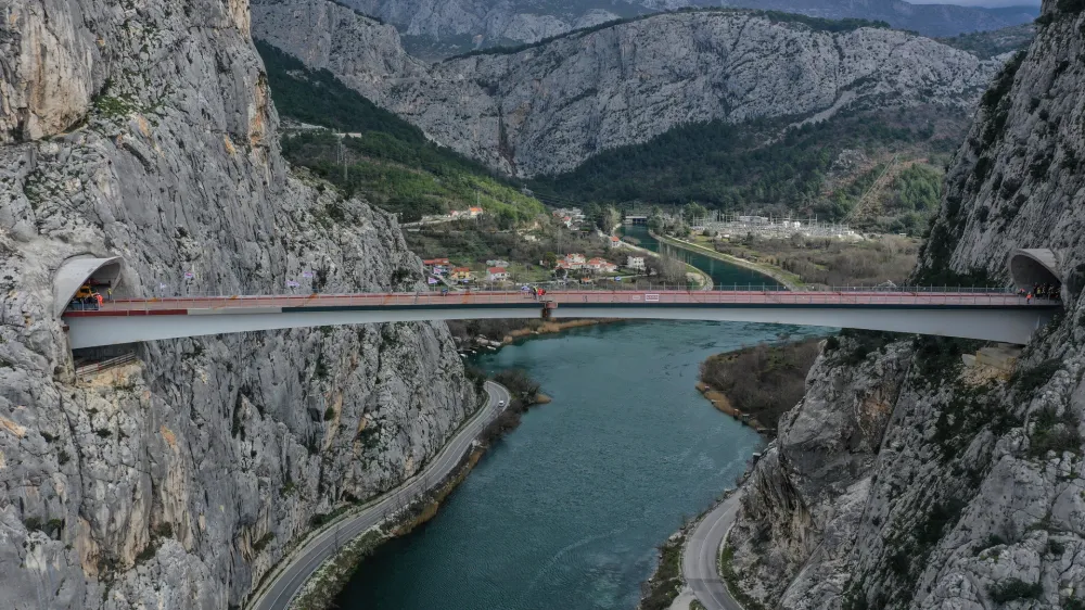 09.03.2023., Omis - Fotografija iz zraka sa svecanosti spajanja mosta iznad rijeke Cetine na obilaznici Omisa. Most Cetina duljine je 224,45 metra i izvodi se u sklopu projekta izgradnje dijela obilaznice Omisa. Vrijednost radova iznosi 174,46 milijuna kuna (bez PDV-a)/ 23,16 milijuna eura, a rijec je o projektu cija ce realizacija doprinijeti prometnom rasterecenju gradske jezgre Omisa i smanjenju guzvi. Photo: Matko Begovic/PIXSELL