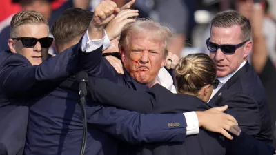 Republican presidential candidate former President Donald Trump pumps his fist as he is helped off the stage at a campaign event in Butler, Pa., on Saturday, July 13, 2024. (AP Photo/Gene J. Puskar)