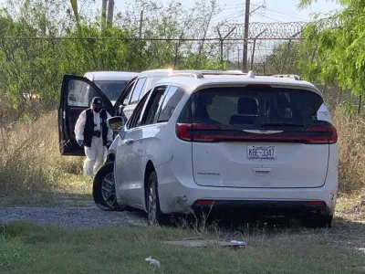 A Mexican police investigator inspects the minivan were four Americans where shot and taken from last week, at the Tamaulipas State prosecutor headquarters in Matamoros, Mexico, Wednesday, March 8, 2023. Their minivan crashed and was fired on shortly after they crossed into the border city of Matamoros on Friday as drug cartel factions tore through the streets, the region's governor said. A stray bullet also killed a Mexican woman about a block and a half away. (AP Photo/STR)