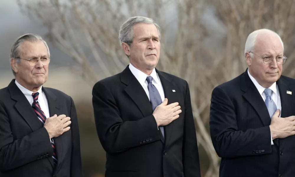 U.S. President George W. Bush, Vice President Dick Cheney (R) and outgoing Secretary of Defense Donald Rumsfeld (L) place their hands over their hearts as the national anthem is played at Rumsfeld's farewell tribute at the Pentagon in Arlington, Virginia, December 15, 2006. Rumsfeld will be replaced by former CIA director Robert Gates.  REUTERS/Kevin Lamarque (UNITED STATES)