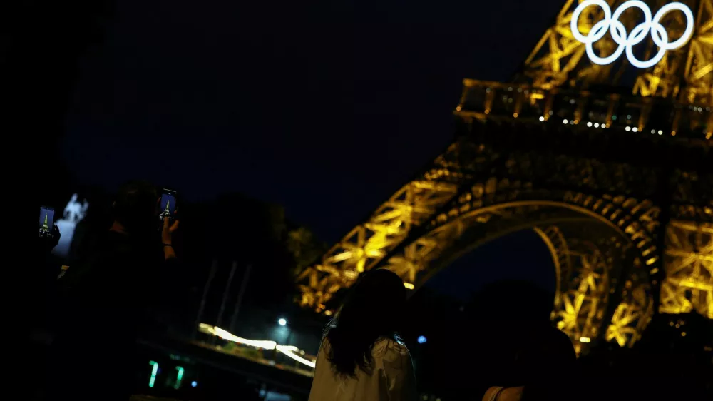 Tourists take pictures of the Eiffel Tower a day before the opening ceremony of the Paris 2024 Olympics, in Paris, France June 25, 2024. REUTERS/Agustin Marcarian