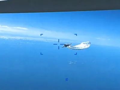 A Russian Su-27 aircraft dumps fuel while flying upon a U.S. Air Force intelligence, surveillance, and reconnaissance unmanned MQ-9 aircraft over the Black Sea, March 14, 2023 in this still image taken from a handout video. Courtesy of U.S. European Command/Handout via REUTERS  THIS IMAGE HAS BEEN SUPPLIED BY A THIRD PARTY. MANDATORY CREDIT.