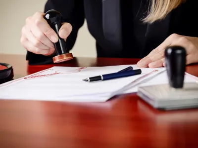 Closeup on notary's public hands stamping document. Notary public accessories