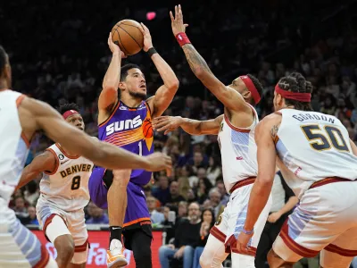 Phoenix Suns guard Devin Booker (1) shoots against the Denver Nuggets during the second half of an NBA basketball game, Friday, March 31, 2023, in Phoenix. (AP Photo/Matt York)