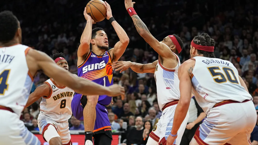 Phoenix Suns guard Devin Booker (1) shoots against the Denver Nuggets during the second half of an NBA basketball game, Friday, March 31, 2023, in Phoenix. (AP Photo/Matt York)