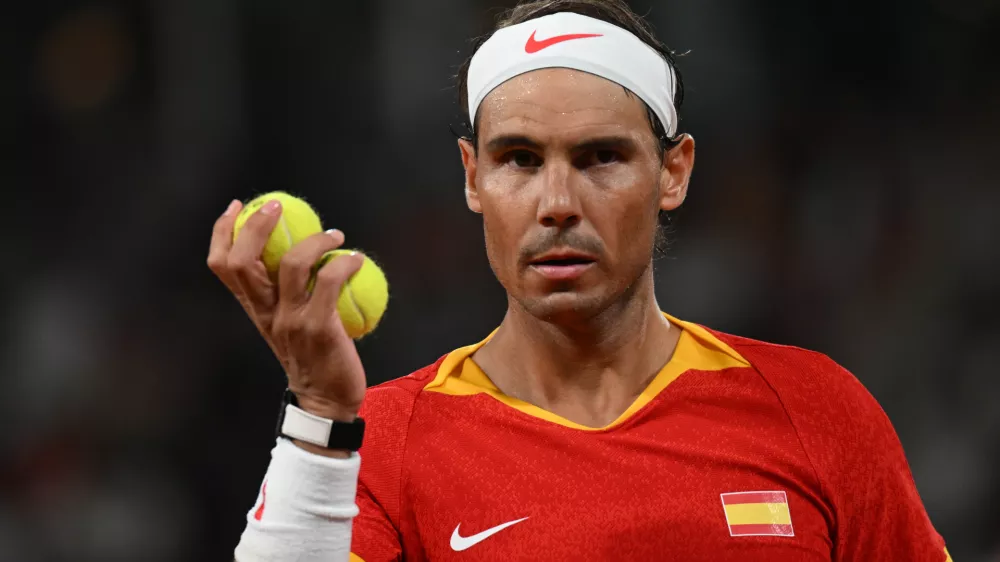 27 July 2024, France, Paris: Spanish tennis player Rafael Nadal holds tennis balls in his hand during his men's doubles 1st round tennis match with Spain's Carlos Alcaraz against Argentina's Maximo Gonzalez and Andres Molteni at Roland-Garros on the first day of the 2024 Paris Olympic Games in France. Photo: Marijan Murat/dpa