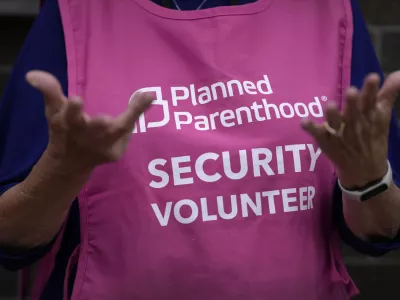 A Planned Parenthood clinic patient escort stands outside the building Thursday, July 18, 2024, in Ames, Iowa. (AP Photo/Charlie Neibergall)