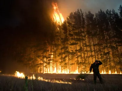 FILE - In this Wednesday, Aug. 4, 2010 picture, a firefighter works to extinguish a forest fire near the village of Dolginino in the Ryazan region, some 180 km (111 miles) southeast of Moscow. The World Meteorological Organization (WMO) says the weather-related cataclysms of July and August fit patterns predicted by climate scientists, although those scientists always shy from tying individual disasters directly to global warming. (AP Photo)