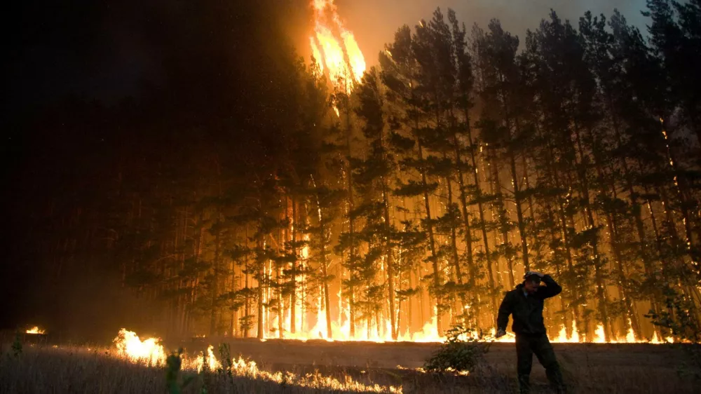 FILE - In this Wednesday, Aug. 4, 2010 picture, a firefighter works to extinguish a forest fire near the village of Dolginino in the Ryazan region, some 180 km (111 miles) southeast of Moscow. The World Meteorological Organization (WMO) says the weather-related cataclysms of July and August fit patterns predicted by climate scientists, although those scientists always shy from tying individual disasters directly to global warming. (AP Photo)