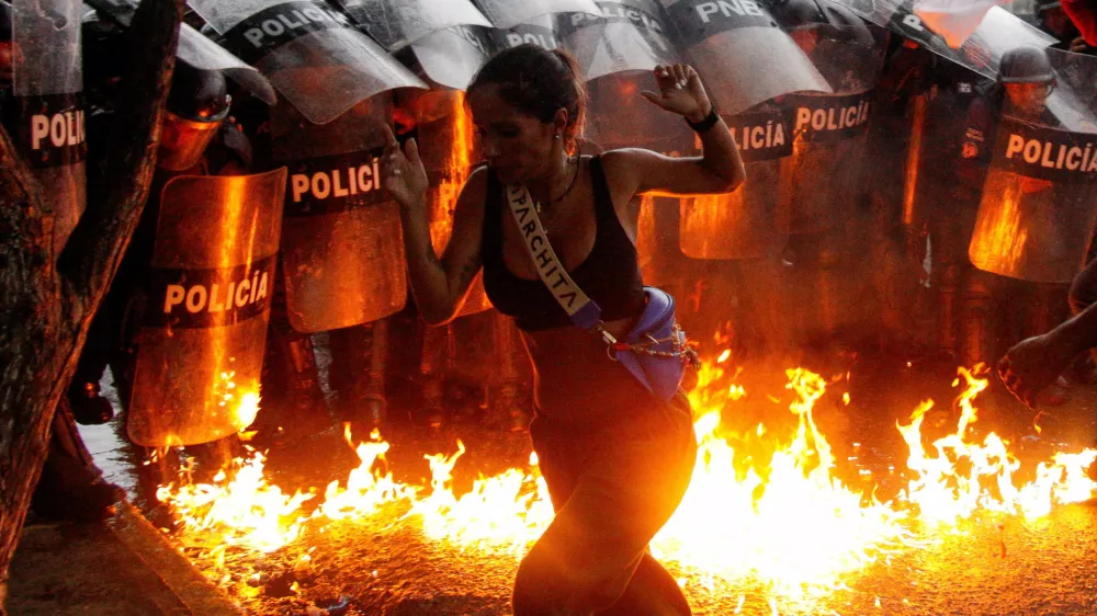 A demonstrator reacts when Molotov cocktails hit the ground in front of security forces during protests against election results after Venezuela's President Nicolas Maduro and his opposition rival Edmundo Gonzalez claimed victory in Sunday's presidential election, in Puerto La Cruz, Venezuela July 29, 2024. REUTERS/Samir Aponte  TPX IMAGES OF THE DAY