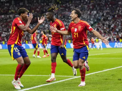 Spain's Mikel Oyarzabal celebrates with Nico Williams and Lamine Yamal, left, after scoring his side's second goal during the final match between Spain and England at the Euro 2024 soccer tournament in Berlin, Germany, Sunday, July 14, 2024. (AP Photo/Manu Fernandez)