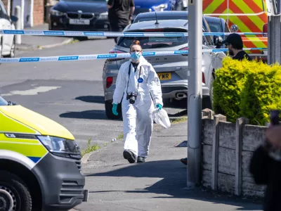 29 July 2024, United Kingdom, Southport: A police scenes of crime officer (SOCO) works at the scene in Southport, Merseyside, where a man has been detained and a knife seized after a number of people were injured in a reported stabbing. Eight patients with stab injuries have been treated at the scene and taken to hospitals including Alder Hey Children's Hospital. Photo: James Speakman/PA Wire/dpa