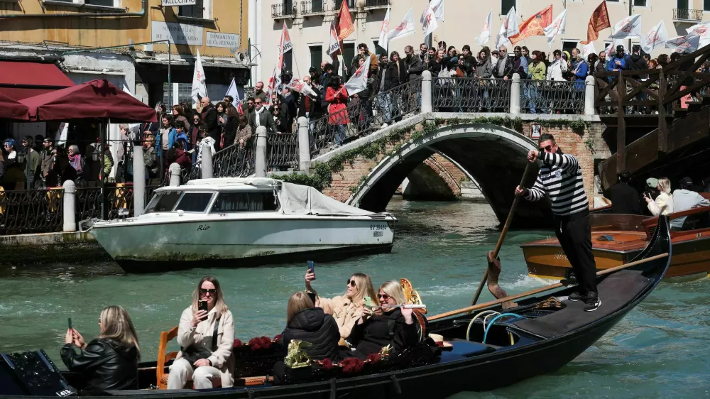 People protest against the introduction of the registration and tourist fee to visit the city of Venice for day trippers introduced by Venice municipality in a move to preserve the lagoon city often crammed with tourists in Venice, Italy, April 25. REUTERS/Manuel Silvestri