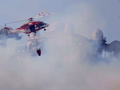 31 July 2024, Italy, Rome: A fire-fighting helicopter tries to extinguish the fire near the courthouse in the Monte Mario area. Photo: Cecilia Fabiano/LaPresse via ZUMA Press/dpa