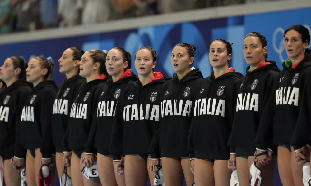 Players from Italy listen to their national anthem prior to a women's water polo group B preliminary match between Italy and USA, at the 2024 Summer Olympics, Wednesday, July 31, 2024, in Saint-Denis, France. (AP Photo/Luca Bruno)