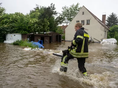 02 June 2024, Bavaria, Wertingen: A firefighter walks across a flooded street. After the heavy rainfall of the last few days, there was severe flooding in the region. Photo: Stefan Puchner/dpa