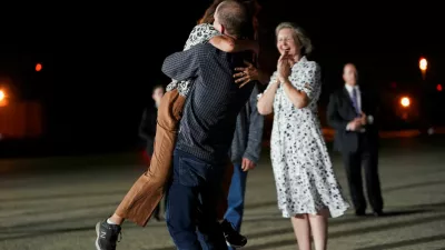 U.S. journalist Evan Gershkovich, who was released from detention in Russia, embraces his mother Ella Milman, as Ex-U.S. Marine Paul Whelan and his sister, Elizabeth Whelan, look on, at Joint Base Andrews in Maryland, U.S., August 1, 2024. REUTERS/Nathan Howard