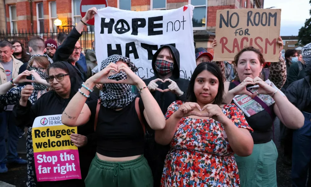 People take part in a protest outside a mosque in Liverpool, Britain, August 2, 2024.  REUTERS/Belinda Jiao