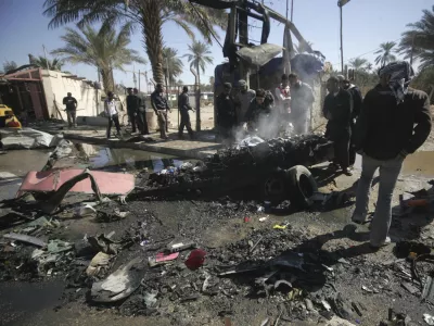 Residents gather at the site of a bomb attack in Kerbala, 110 km (70 miles) south of Baghdad, March 20, 2012. At least 16 near-simultaneous explosions struck cities and towns across Iraq on Tuesday, killing at least 43 people and wounding more than 200, despite a massive security clampdown ahead of next week's Arab League summit. REUTERS/Mushtaq Muhammed (IRAQ - Tags: CONFLICT POLITICS CIVIL UNREST)