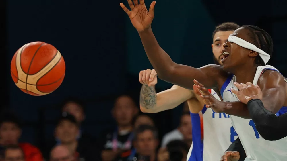 Paris 2024 Olympics - Basketball - Men's Quarterfinal - France vs Canada - Bercy Arena, Paris, France - August 06, 2024. Frank Ntilikina of France is seen with his headband over his eyes while players interact during the match. REUTERS/Brian Snyder