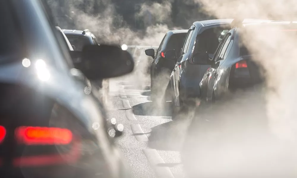 ﻿Moscow, Russia - August 08, 2017: Traffic jam. Blurred silhouettes of cars surrounded by steam from the exhaust pipes. Environmental pollution