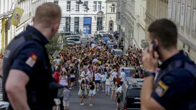 Austrian police officers watch swifts gathering in the city centre in Vienna on Thursday, Aug.8, 2024. Organizers of three Taylor Swift concerts in the stadium in Vienna this week called them off on Wednesday after officials announced arrests over an apparent plot to launch an attack on an event in the Vienna area such as the concerts. (AP Photo/Heinz-Peter Bader)