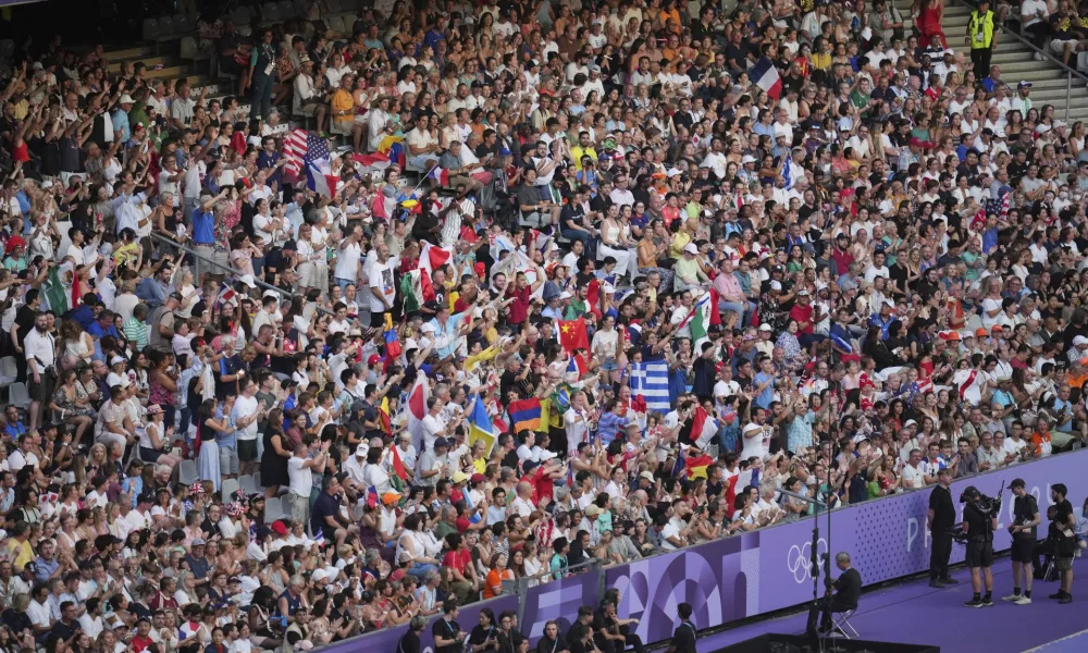 Spectators watch the 2024 Summer Olympics closing ceremony at the Stade de France, Sunday, Aug. 11, 2024, in Saint-Denis, France. (AP Photo/Kin Cheung)